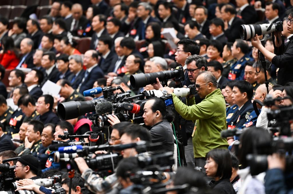 3月8日，十四屆全國人大二次會議在北京人民大會堂舉行第二次全體會議。這是記者在會議現(xiàn)場采訪。新華社記者 牟宇 攝